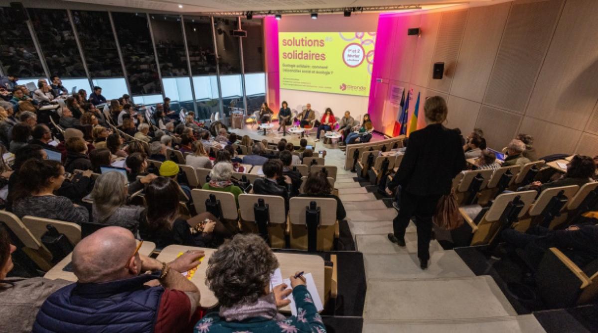 Un public face à des intervenants lors d'une table ronde